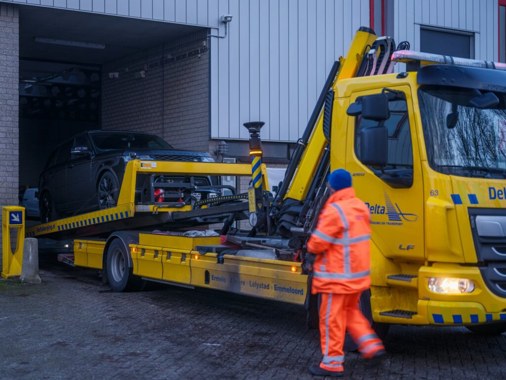 Recovery driver in hi-vis beside a recovery truck